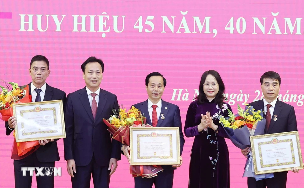 Đồng chí Lâm Thị Phương Thanh, Ủy viên Trung ương Đảng, Bí thư Đảng ủy, Phó Chánh Văn phòng Thường trực Trung ương Đảng và đồng chí Lại Xuân Lâm, Phó Bí thư Đảng ủy Khối các Cơ quan Trung ương trao Huy hiệu 30 năm tuổi Đảng cho các đảng viên. (Ảnh: Thống Nhất/TTXVN)