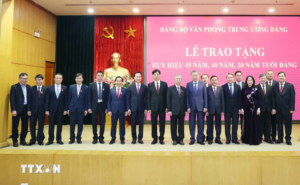 Tổng Bí thư Tô Lâm và các đại biểu chụp ảnh chung với các đảng viên nhận Huy hiệu Đảng. (Ảnh: Thống Nhất/TTXVN)