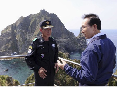 Tổng thống Hàn Quốc Lee Myung-bak nói chuyện với một sĩ quan cảnh sát trên đảo Dokdo/Takeshima hôm 10-8. Nguồn: AP