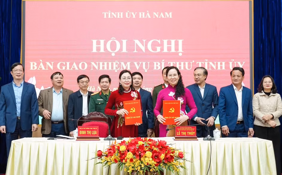 Bà Lê Thị Thủy và bà Đinh Thị Lụa ký biên bản bàn giao nhiệm vụ. Ảnh: Vũ Hà.
