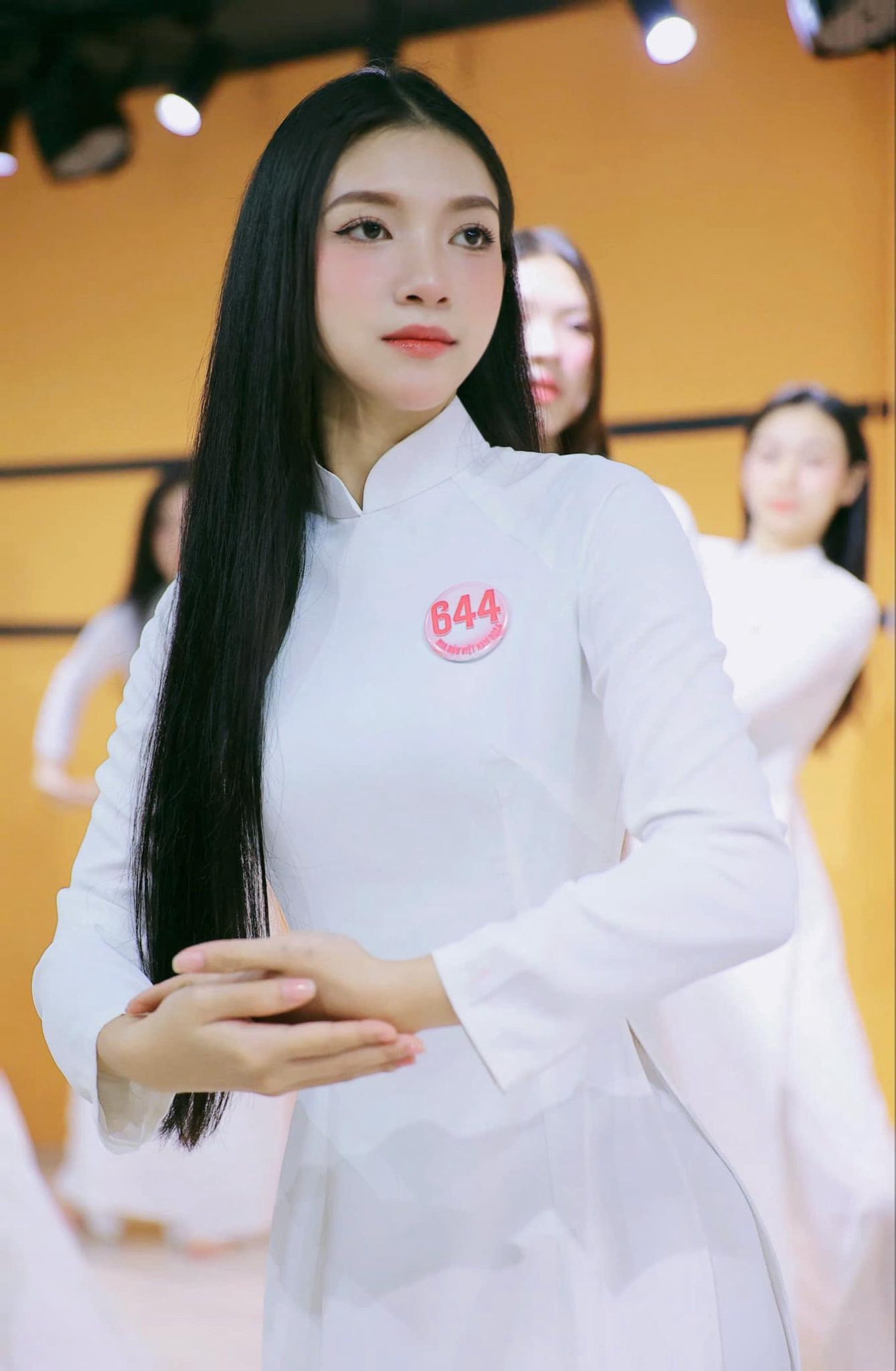 Vũ Yến khoe nhan sắc trong trẻo, dịu dàng với tà áo dài trắng trong buổi học múa trước thềm sơ khảo. Cô có gương mặt bầu bĩnh, mái tóc đen dài, thẳng tự nhiên.