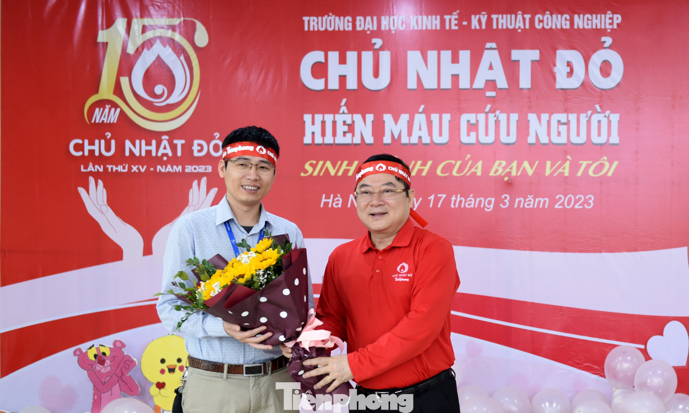 Nhà báo Lê Xuân Sơn tặng hoa PGS.TS Nguyễn Hữu Quang. Ảnh: Xuân Tùng
