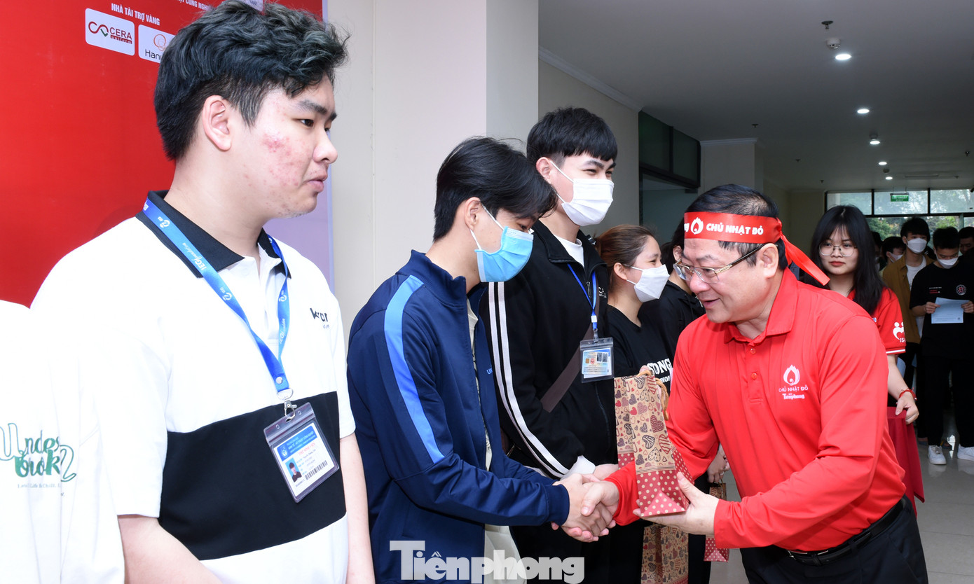 Ban Tổ chức chương trình thăm, động viên người tham gia hiến máu; tặng quà 10 người hiến máu sớm nhất. Ảnh: Xuân Tùng