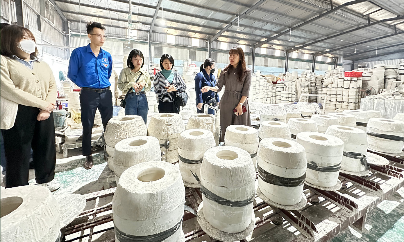 Các học viên tham quan tìm hiểu làng nghề Bát Tràng. Bà Phạm Thị Thu Hoài - Phó Bí thư thường trực Đảng ủy xã Bát Tràng đã giới thiệu về địa phương và nghề làm gốm ở Bát Tràng. Anh Nguyễn Quang Cảnh lớp trưởng đại diện các học viên tặng quà lưu niệm tới xã Bát Tràng. Ảnh: Xuân Tùng