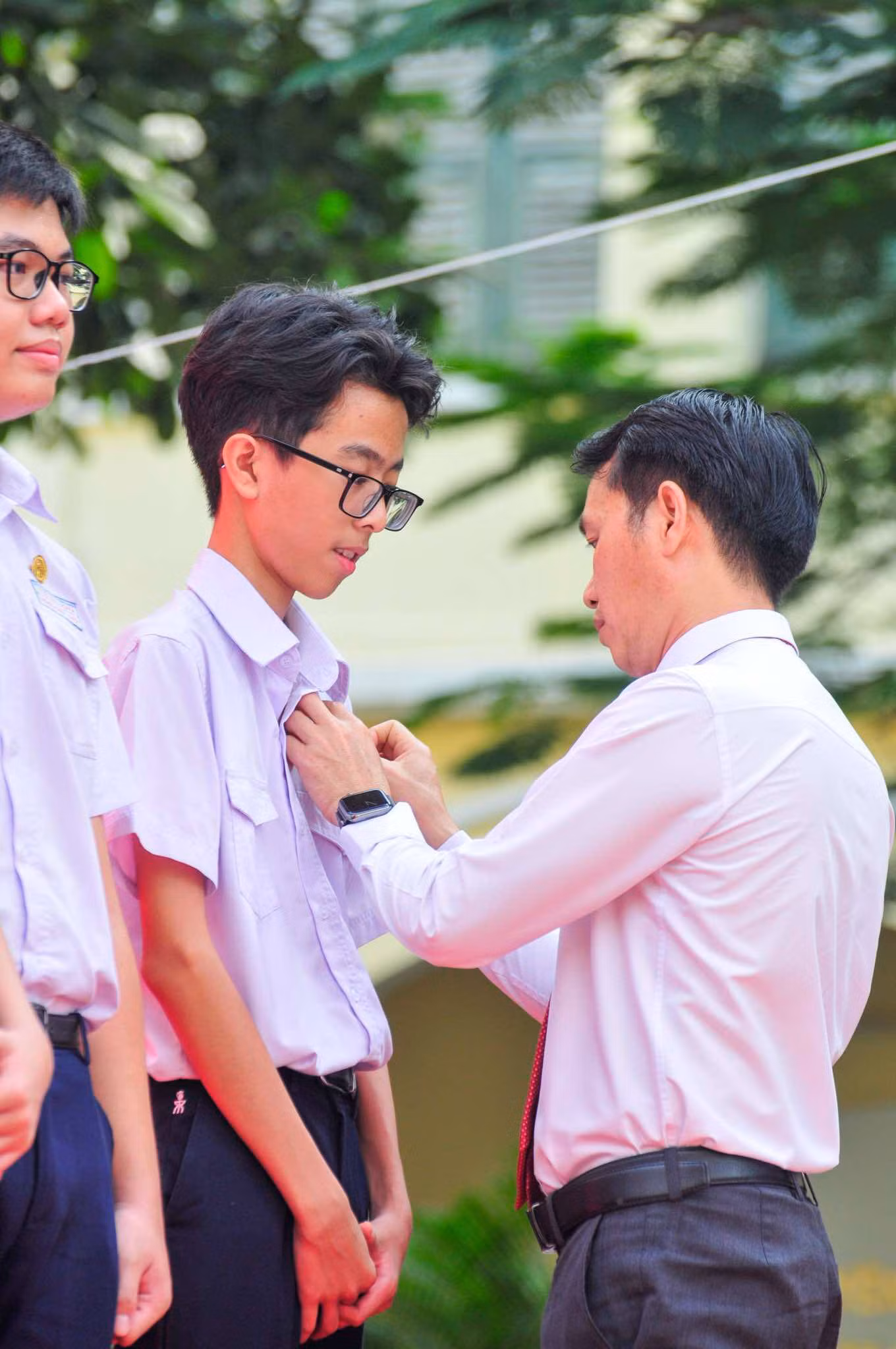 Giây phút thầy Hiệu trưởng huy hiệu cho các em học sinh. Ảnh: Hoàng Lam