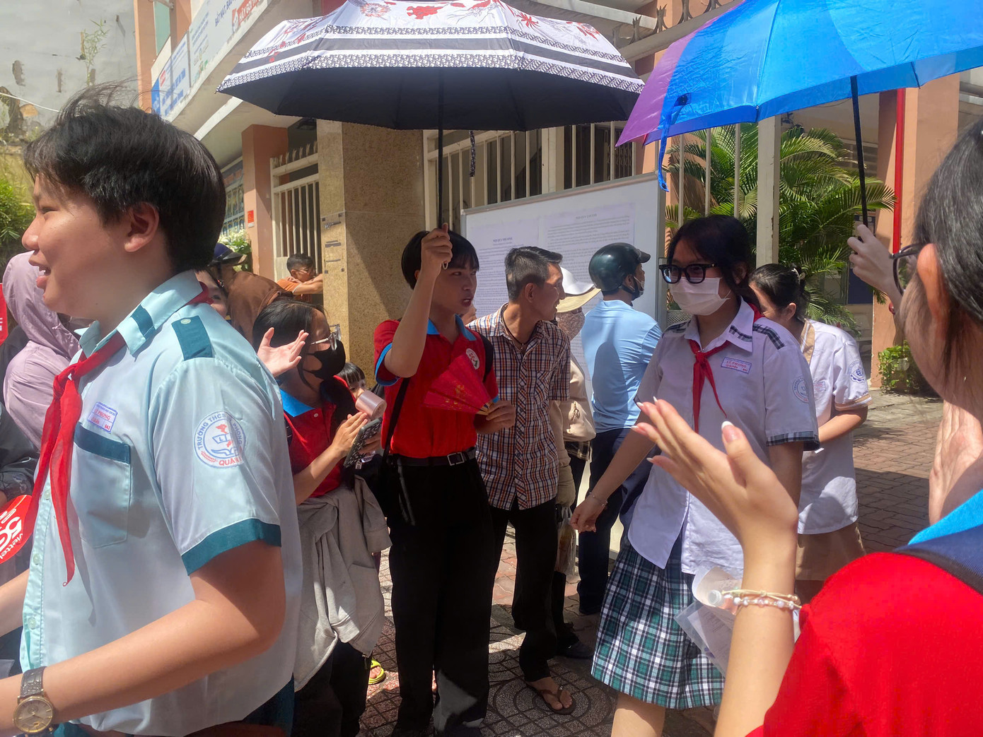 Các bạn tình nguyện viên chu đáo che chắn cho các bạn thí sinh sau khi thi xong. Ảnh: Lê Sơn. Các bạn tình nguyện viên chu đáo che chắn cho các bạn thí sinh sau khi thi xong. Ảnh: Lê Sơn.