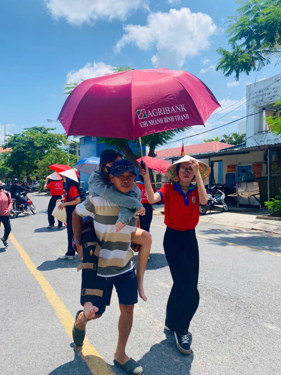 Các bạn tình nguyện viên hỗ trợ phụ huynh học sinh che nắng để đến phòng thi. Ảnh: Đoàn Trường THPT Nguyễn Hữu Cảnh. Các bạn tình nguyện viên hỗ trợ phụ huynh học sinh che nắng để đến phòng thi. Ảnh: Đoàn Trường THPT Nguyễn Hữu Cảnh.