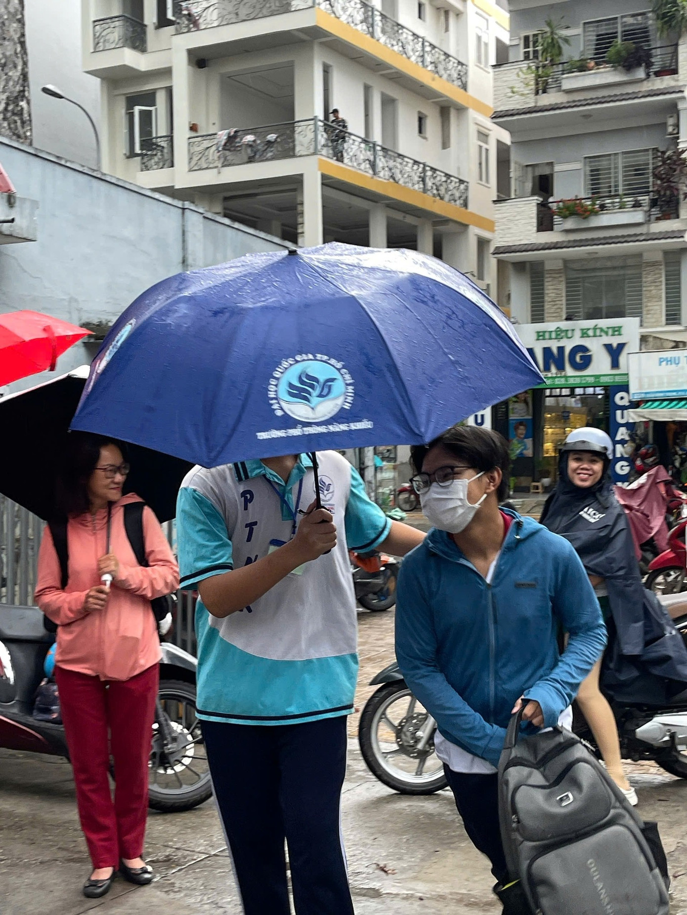 Các bạn tình nguyện viên chuẩn bị sẵn ô để giúp các thí sinh bình tĩnh và thuận tiện di chuyển vào phòng thi chiều ngày 24/5. Ảnh: Trường Phổ thông Năng khiếu - ĐHQG TP.HCM