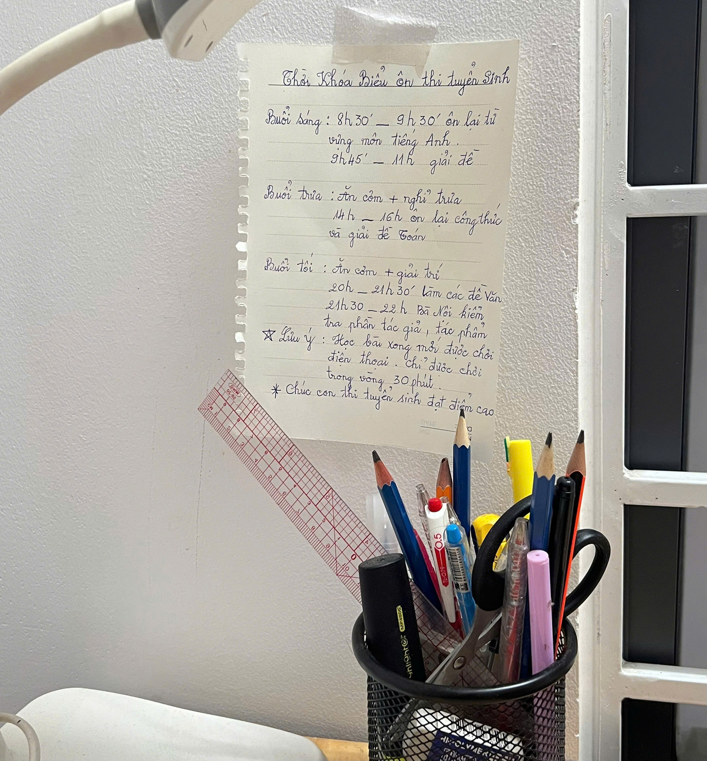 Thời khóa biểu được dán trước mặt bàn học như một lời nhắc nhở, động viên cháu nội. Ảnh: Phương Anh