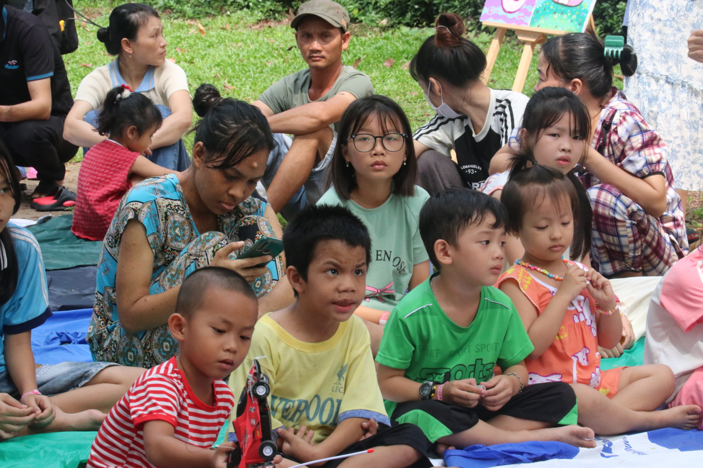 Các bé chăm chú xem anh chị biểu diễn văn nghệ.