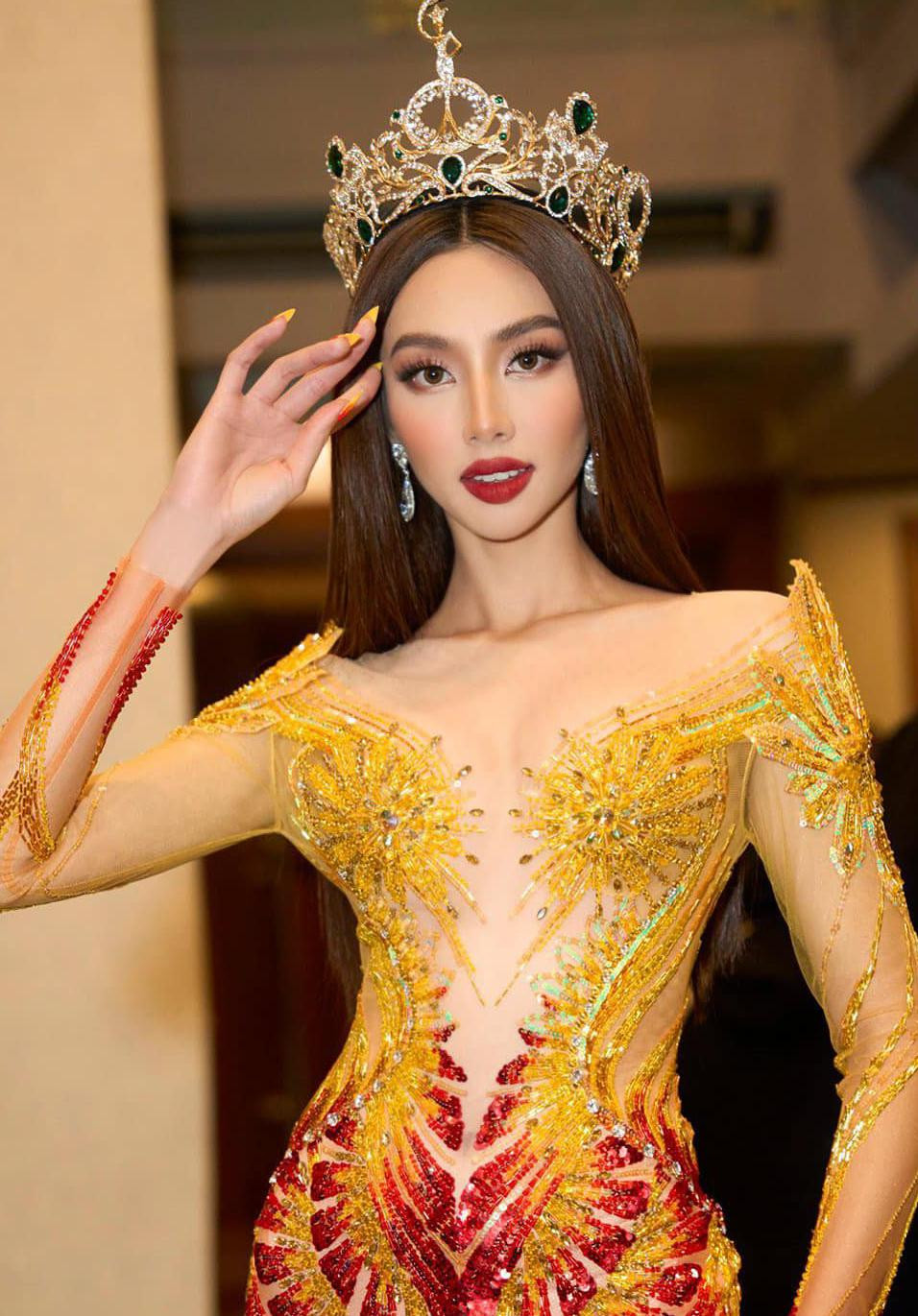 Trong khi các hoa hậu khác đều lựa chọn tông màu vàng gold hoặc ánh bạc thì việc mặc đầm với hai tông màu vàng - đỏ giúp Thùy Tiên nổi bật ở vị trí trung tâm. Điểm nhấn của bộ trang phục là những chi tiết đính kết cầu kỳ ở phần thân trên giúp người đẹp khoe vẻ quyến rũ.