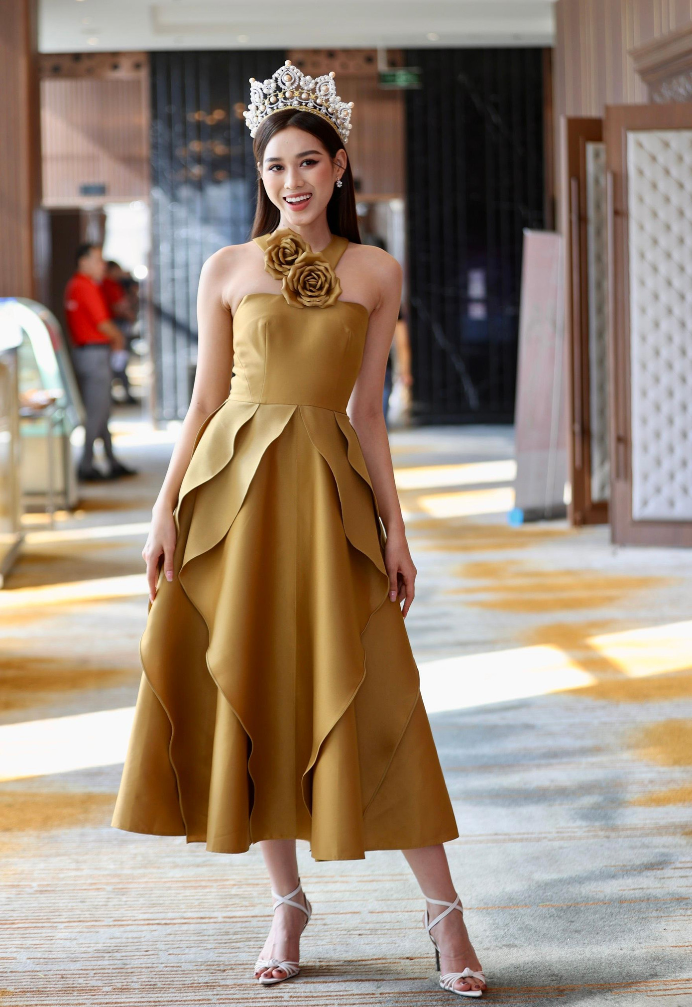 Hoa hậu Đỗ Thị Hà mặc váy xếp ly màu nâu với điểm nhấn là hình bông hoa hồng ở ngực áo. Sau khi đăng quang Hoa hậu Việt Nam 2020, Đỗ Thị Hà đại diện Việt Nam tham dự Miss World 2021 và vào top 13 chung cuộc.