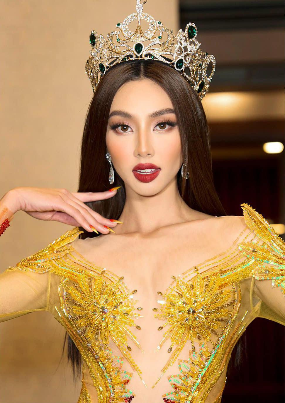 Trong khi các hoa hậu khác đều lựa chọn tông màu vàng gold hoặc ánh bạc thì việc mặc đầm với hai tông màu vàng - đỏ giúp Thùy Tiên nổi bật ở vị trí trung tâm. Điểm nhấn của bộ trang phục là những chi tiết đính kết cầu kỳ ở phần thân trên giúp người đẹp khoe vẻ quyến rũ.