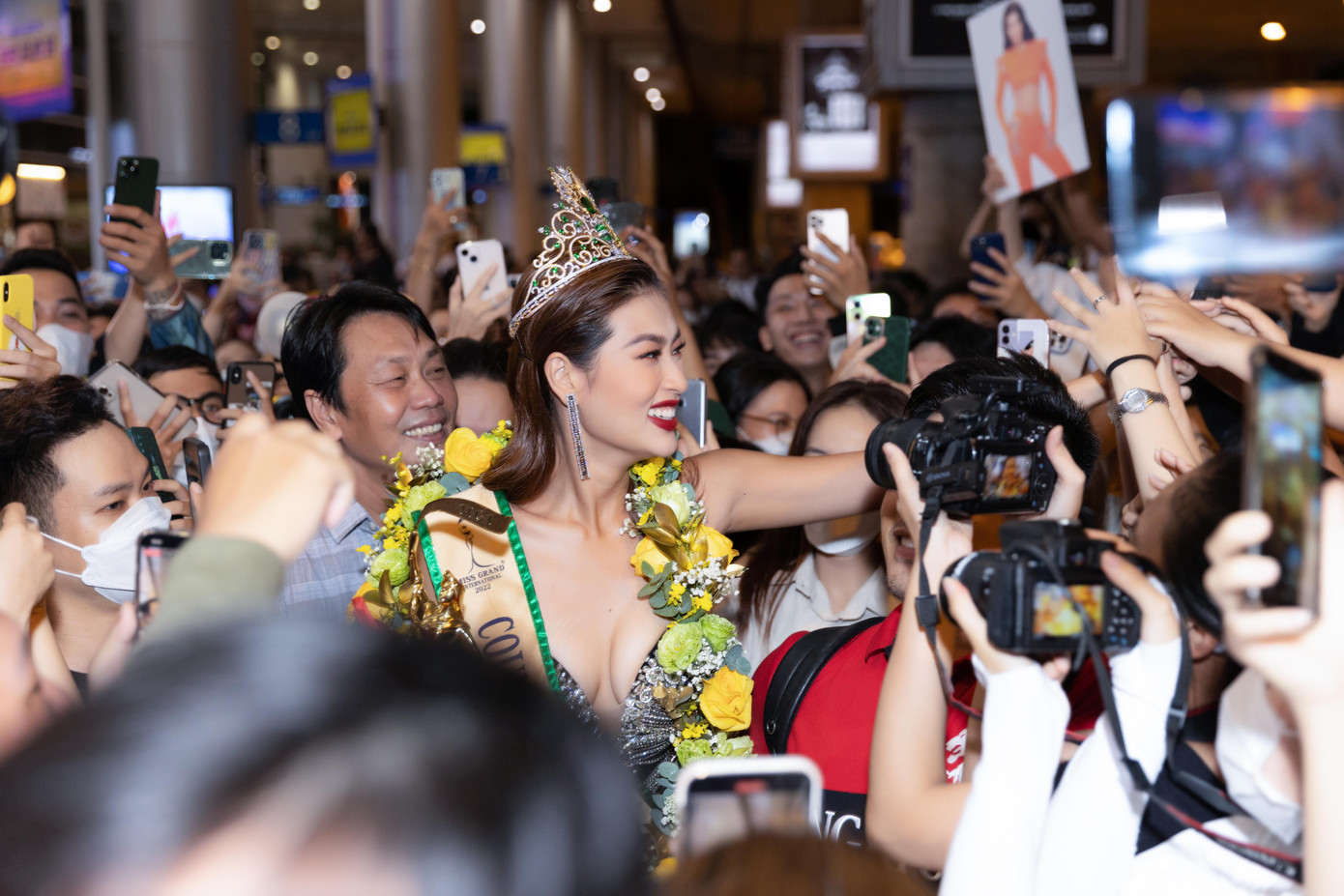 Tình trạng chen lấn xô đẩy diễn ra khi Thiên Ân xuất hiện ở cổng sân bay. Mặc dù vậy người đẹp vẫn tươi cười, dặn dò các fan cẩn thận để không chen nhau.