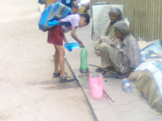 Cậu học sinh đang chia sẻ chút nước hiếm hoi của mình cho những người già không nơi nương tự