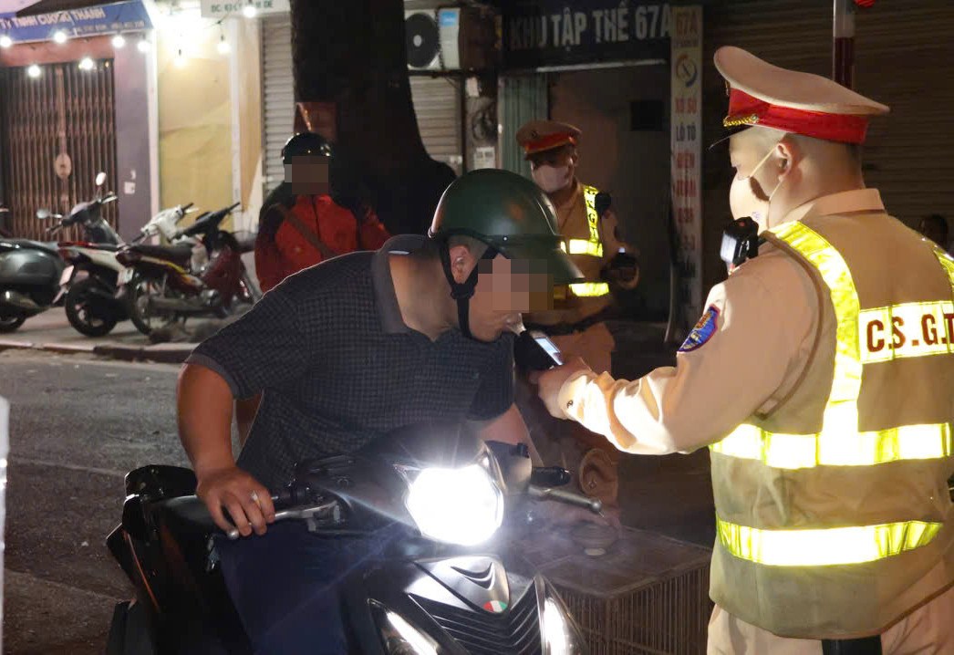 Tài xế xe máy kiểm tra nồng độ cồn.