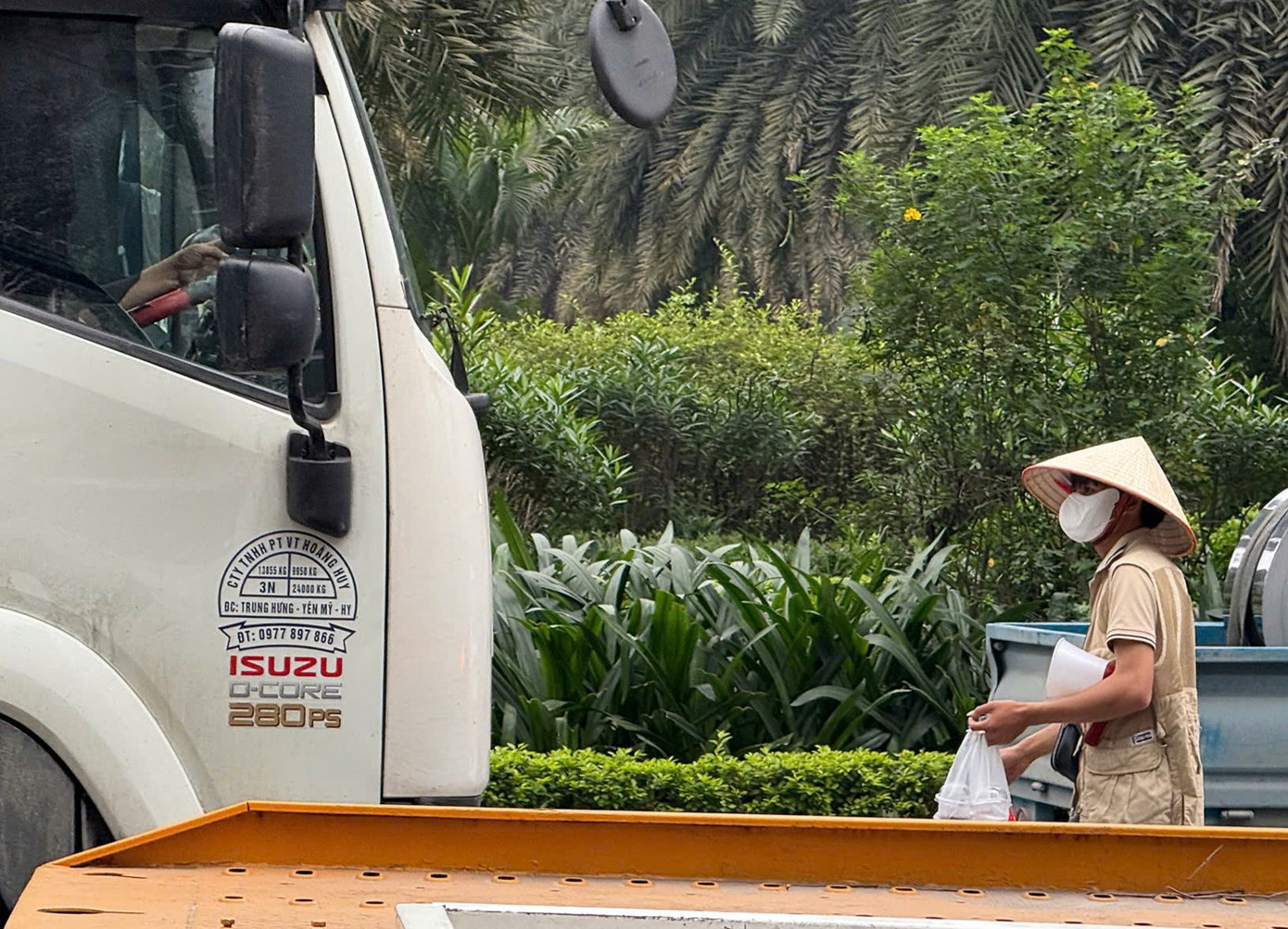 Nam thanh niên đi bộ dưới lòng đường bán cà phê.