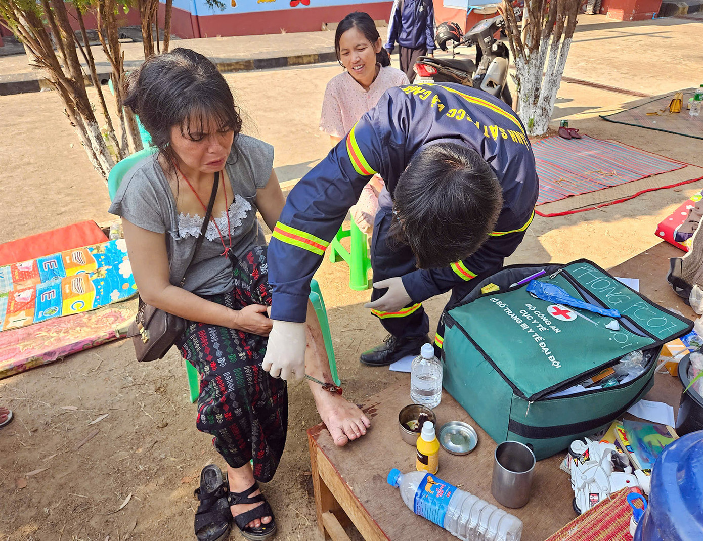 Cán bộ đoàn cứu hộ xử lý vết thương cho người dân. Ảnh: Lê Hoàng
