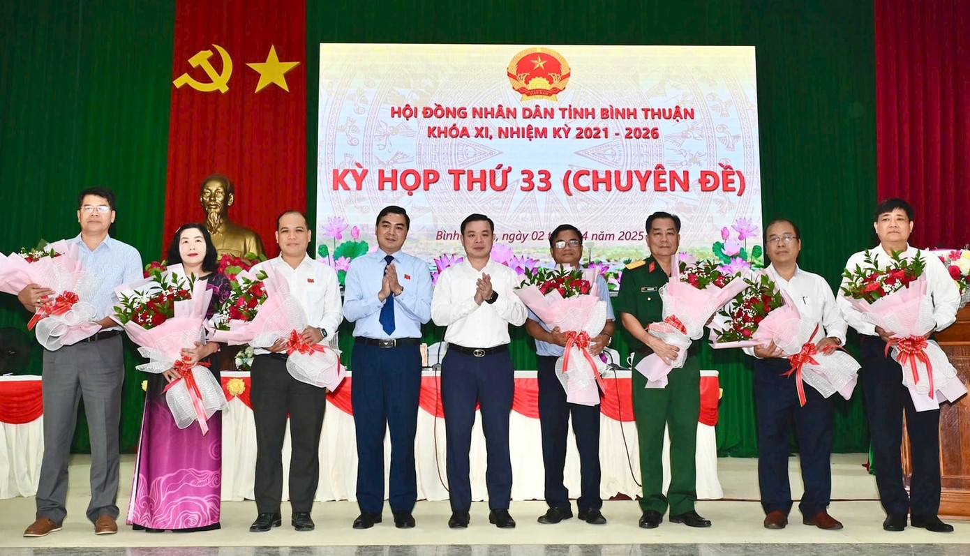 Lãnh đạo HĐND và UBND tỉnh Bình Thuận tặng hoa các tân Ủy viên UBND tỉnh và các cá nhân vừa được miễn nhiệm chức vụ Ủy viên UBND tỉnh để bố trí công tác khác. Ảnh: Báo Bình Thuận.