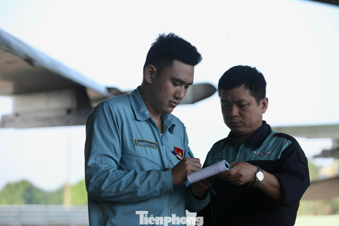Phi công Nguyễn Thái Dương ký biên bản xác nhận cùng nhân viên kỹ thuật sau khi kiểm tra từng góc cạnh của động cơ, thân máy bay.