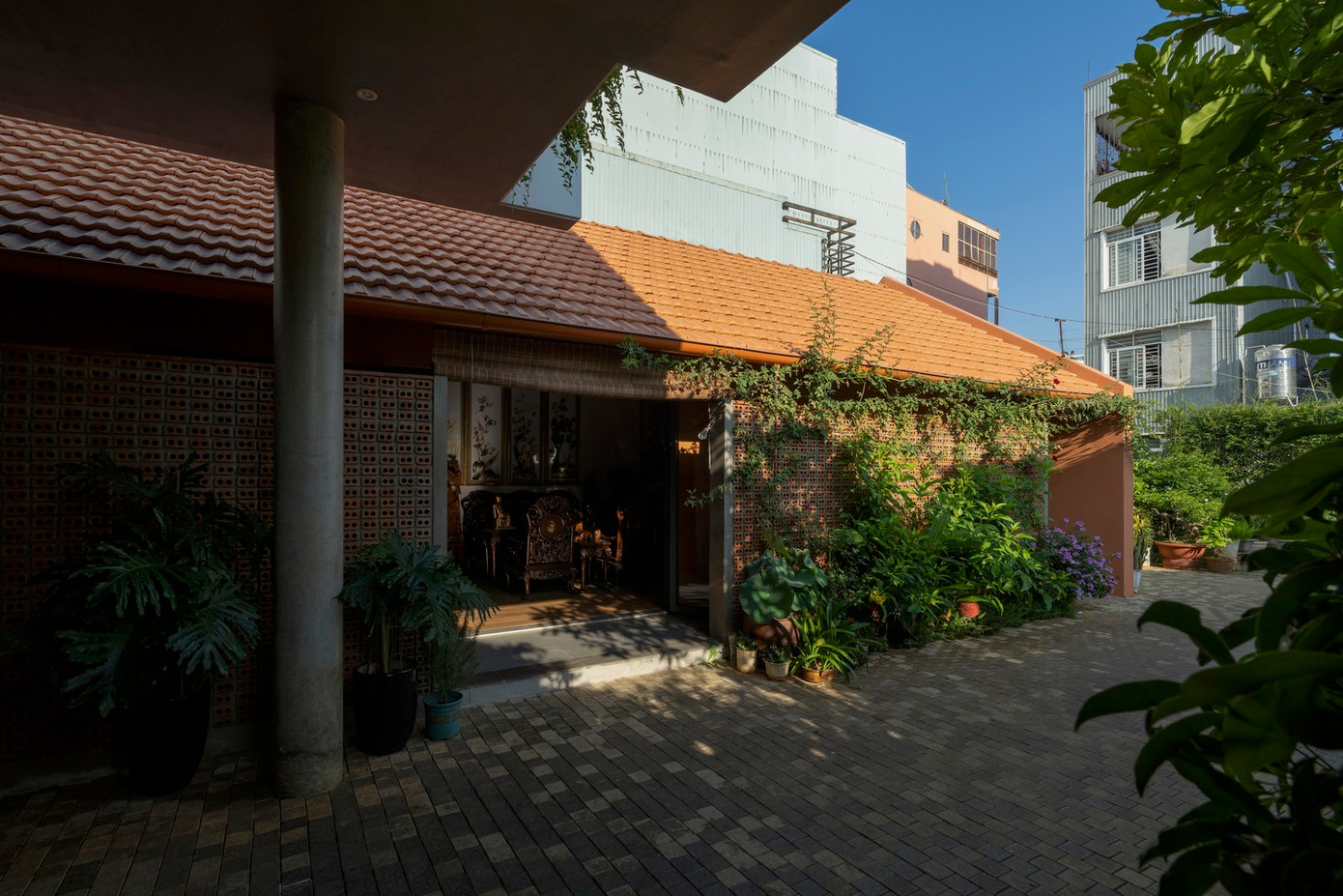 Hiên nhà đóng vai trò là vùng đệm lớn ở phía trước ngôi nhà, giúp giảm tác động nhiệt từ bên ngoài đồng thời cung cấp không gian linh hoạt để đỗ xe, tổ chức các sự kiện gia đình và các nghi lễ thờ cúng tổ tiên.