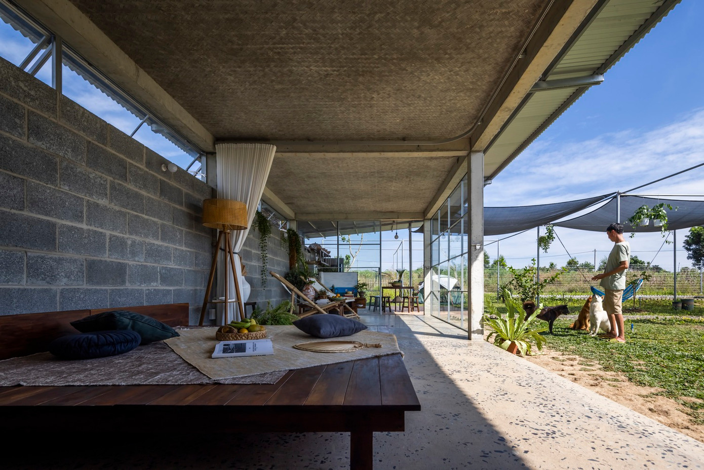 Cấu trúc bê tông và tường khối xác định không gian nội thất tối thiểu, trong khi mái thép nổi nhô ra ngoài để tạo không gian phòng ăn và bếp bán ngoài trời. Cấu trúc bê tông và tường khối xác định không gian nội thất tối thiểu, trong khi mái thép nổi nhô ra ngoài để tạo không gian phòng ăn và bếp bán ngoài trời.
