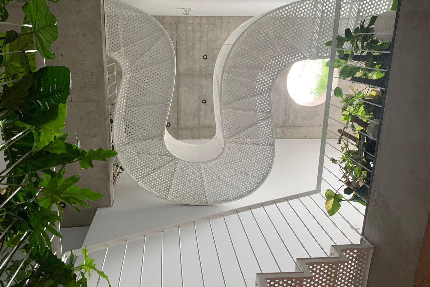 Cầu thang sử dụng khung thép nhưng định hình bằng các đường nét mềm mại, uyển chuyển, giống như một dải lụa mỏng.