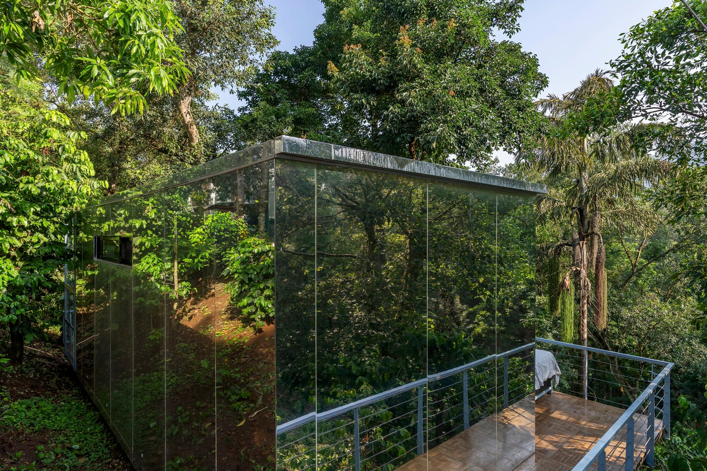 Khu vực chính của ngôi nhà được thiết kế nâng cao hơn tạo cảm giác như lạc vào ốc đảo, trôi nổi độc đáo. Xung quanh ngôi nhà được lắp kính gương nên dễ dàng cảm nhận và chiêm ngưỡng sắc xanh thiên nhiên từ cây cối và cảnh vật xung quanh.