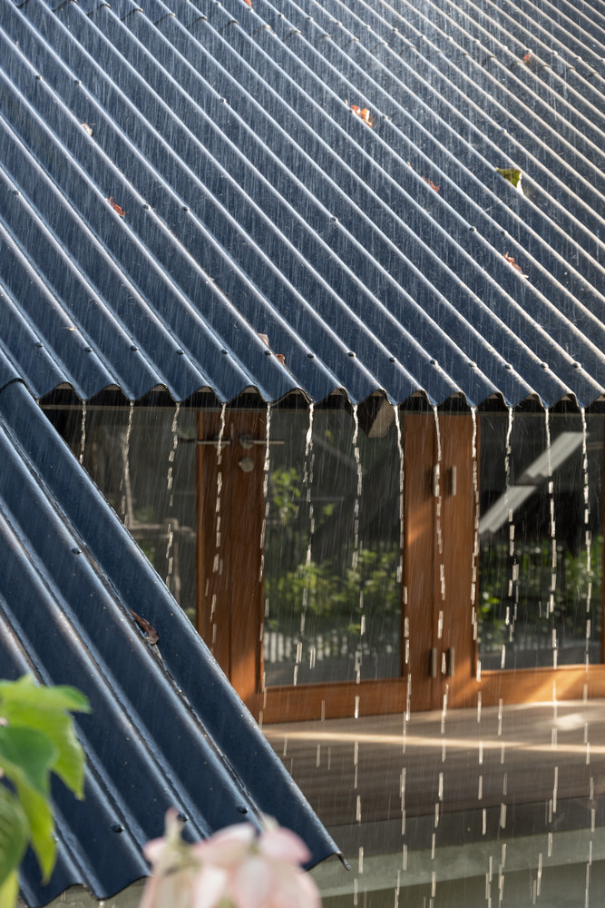 Mái nhà được thiết kế không có máng xối để nước đổ trực tiếp xuống đất, giữ lại mối quan hệ tự nhiên.