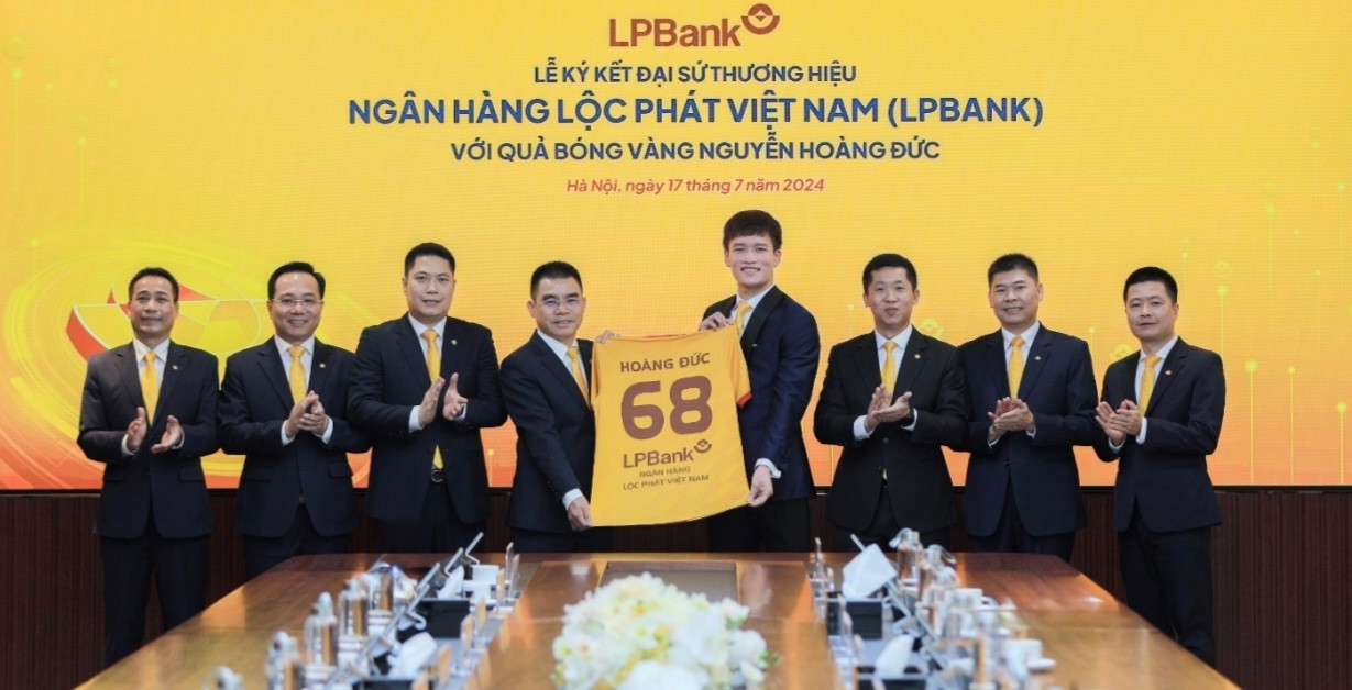 Ông Hồ Nam Tiến – Tổng Giám đốc LPBank (trái) trao tặng trang phục 2 cho Hoàng Đức - Đại sứ thương hiệu của Ngân hàng Lộc Phát Việt Nam (phải)