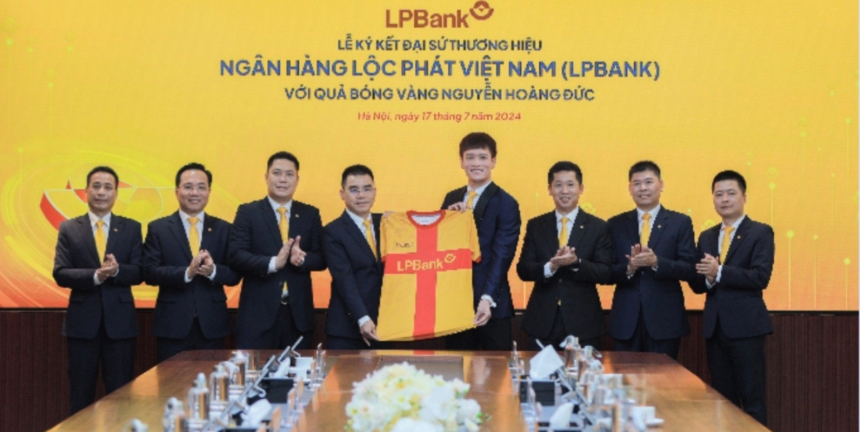 Ông Hồ Nam Tiến – Tổng Giám đốc LPBank (trái) trao tặng trang phục 2 cho Hoàng Đức - Đại sứ thương hiệu của Ngân hàng Lộc Phát Việt Nam (phải)