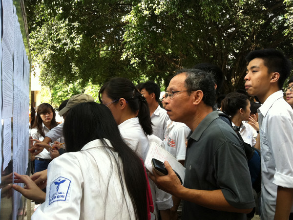 Phu huynh cẩn thận vào ghi số báo danh, phòng thi cùng con