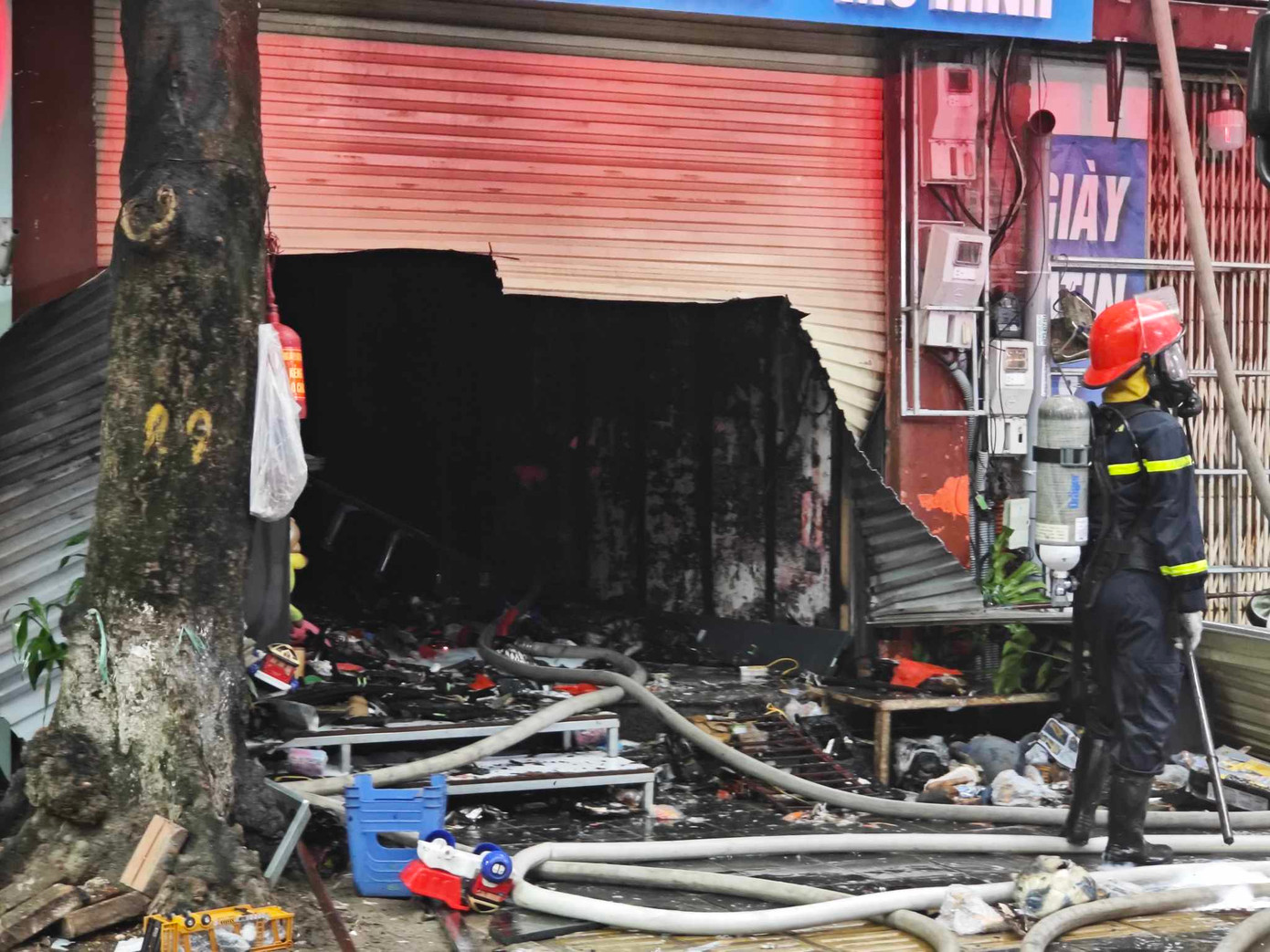 Lực lượng chữa cháy phá cửa cuốn bên ngoài ngôi nhà. Lực lượng chữa cháy phá cửa cuốn bên ngoài ngôi nhà.