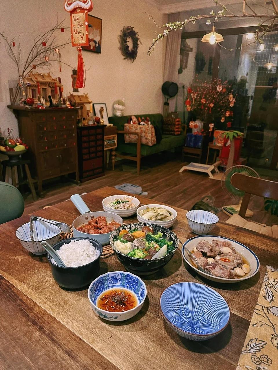 Jun Phạm tự trang hoàng nhà cửa với hoa tuyết mai, cành đào... Nam ca sĩ chuẩn bị mâm cơm tất niên hấp dẫn.