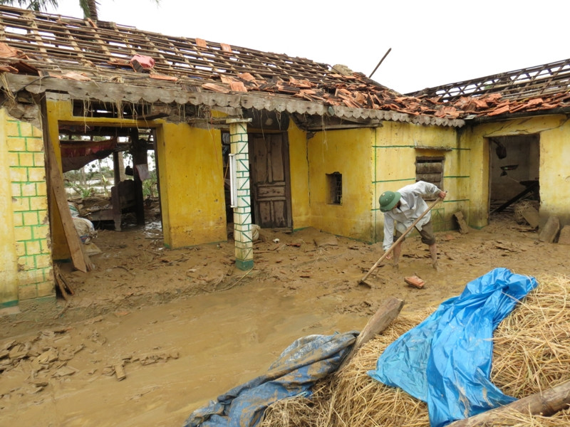 Ông Lới đang dùng cuốc xỉa để cào đống đổ nát