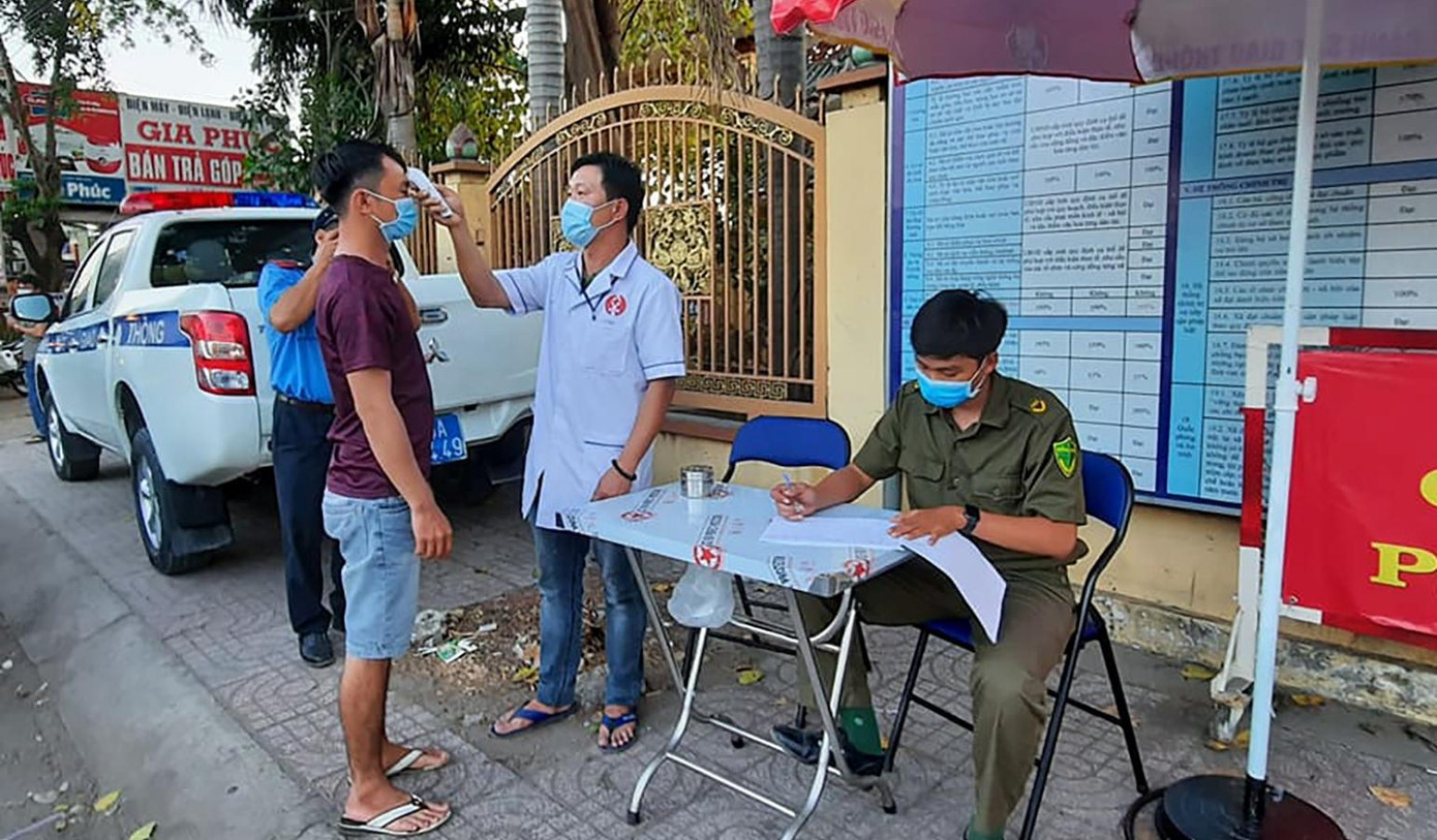 Đo thân nhiệt cho người tham gia lưu thông qua chốt. Ảnh chụp tháng 4/2020 Đo thân nhiệt cho người tham gia lưu thông qua chốt. Ảnh chụp tháng 4/2020