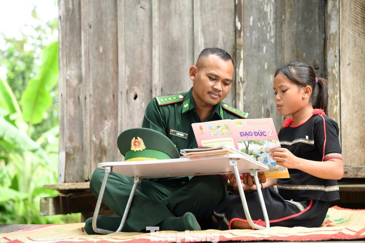 Cán bộ Đồn Biên phòng Sê Rê Pốk, Bộ đội Biên phòng Đắk Lắk hướng dẫn con nuôi của đồn Biên phòng học bài.