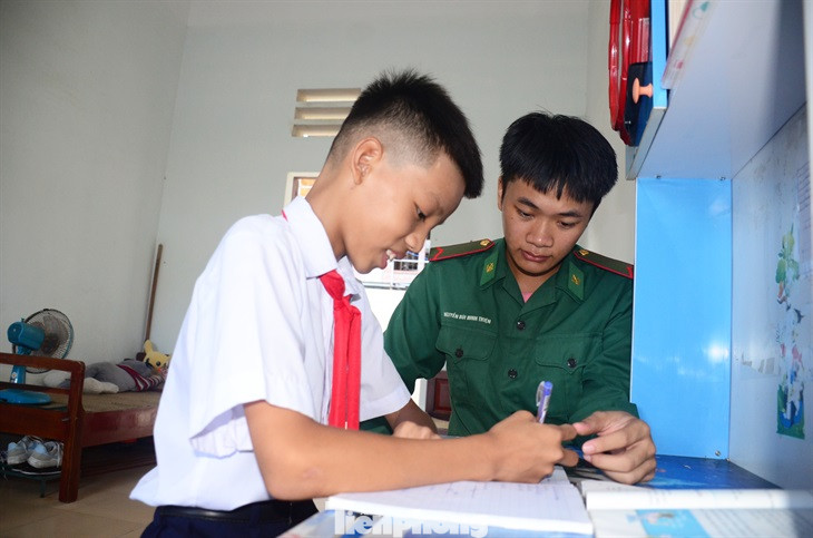 Cán bộ Bộ đội Biên phòng động viên, hướng dẫn "con nuôi đồn biên phòng" học tập.