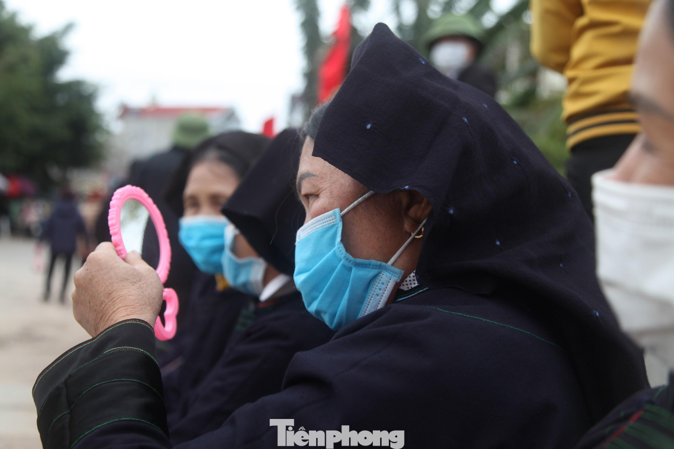 Một người phụ nữ Nùng soi gương trang điểm để đợi bạn hát tại chợ tình Tân Sơn