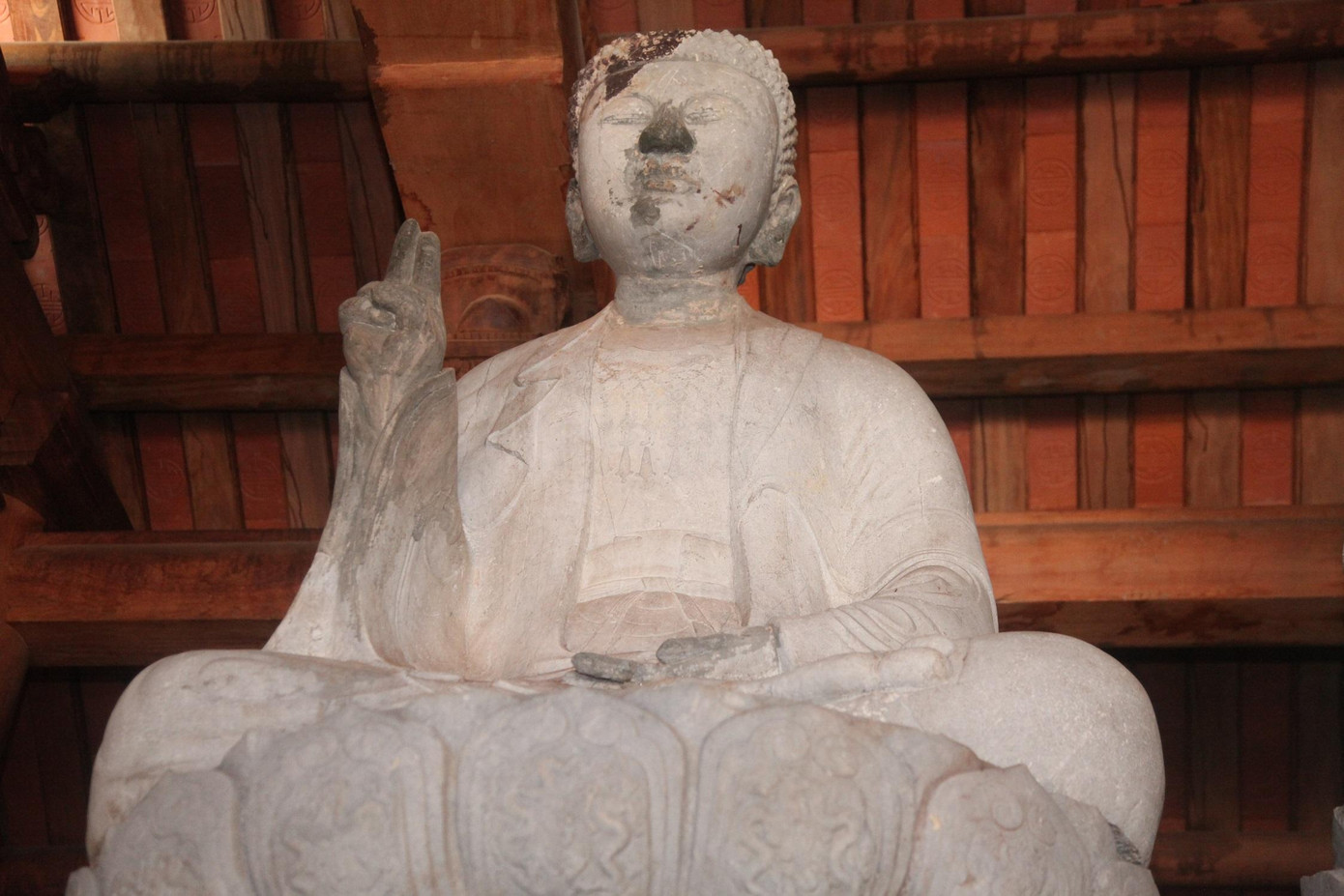 Pho tượng bên trái có chiều cao (cả tượng và bệ) là 259 cm. Pho tượng tạc ba lớp áo mềm mại. Đầu tượng to, tóc xoắn ốc, khuôn mặt đầy đặn phúc hậu.