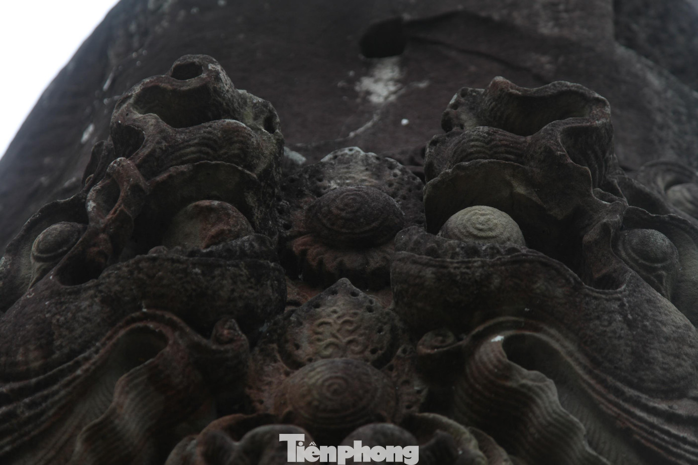 Hai đầu rồng trong tư thế chầu nhau, ở giữa có một lá đề chạm nổi. Mỗi con rồng ngậm một viên ngọc, mắt hướng lên trời, thân rồng uốn khúc.