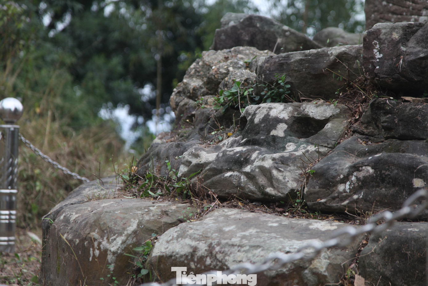 Bao quanh phần đế cột là hai hàng đá xây chồng (kích thước mỗi khối đá khoảng 30x50cm) được chạm khắc hình cánh sen.