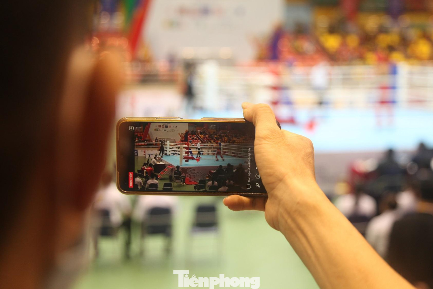Một cổ động viên phát trực tiếp trận đấu của môn Kickboxing tại SEA Games 31