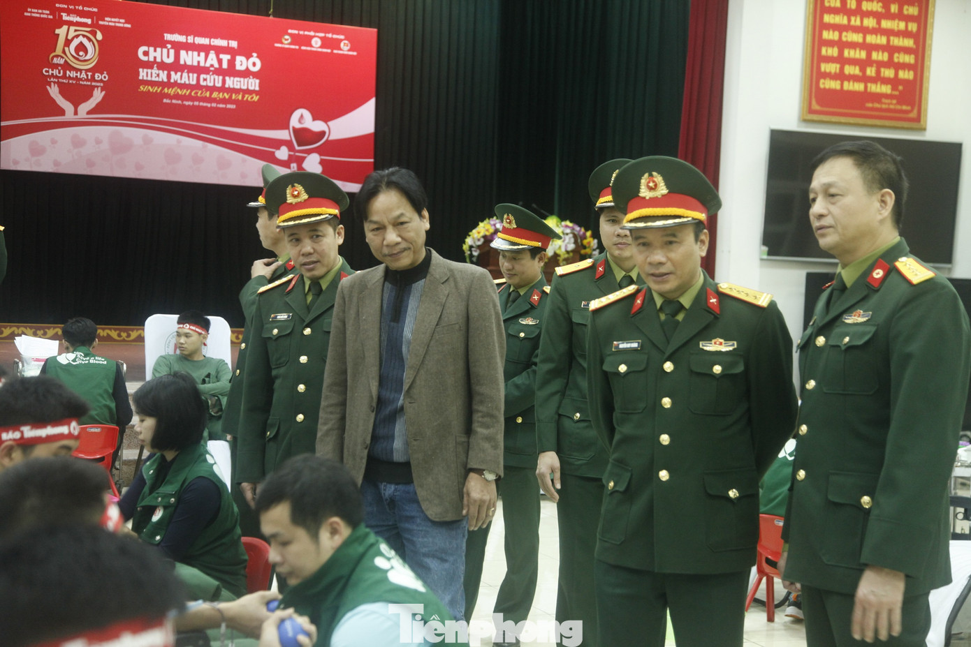 Lãnh đạo Trường Sỹ quan Chính trị và nhà báo Lê Minh Toản - Phó Tổng biên tập báo Tiền Phong (thứ 2 bên trái) động viên, thăm hỏi các cán bộ và học viên trong trường đến tham gia Chủ nhật Đỏ.