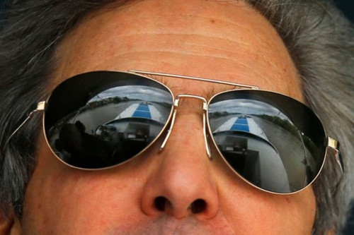 Mặc chiếc áo sơ mi caro xanh, đeo kính râm, Kerry được các quan chức và trợ lý vây quanh trên tàu nhưng phần lớn thời gian ông im lặng, trầm tư. Trong ảnh, phong cảnh sông nước Cà Mau phản chiếu trên mắt kính Kerry. Ảnh: Bộ Ngoại giao Mỹ