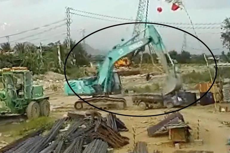 Ô tô tải bị xe máy múc đập nát trước lán trại (Ảnh cắt từ clip).