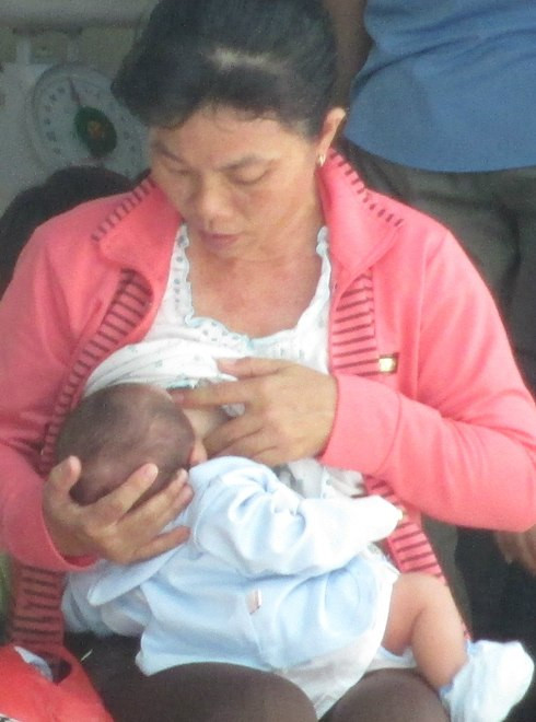 Một bà mẹ đang chờ đến lượt cho con chích ngừa viêm gan B tại Bệnh viện Từ Dũ, TP HCM, sáng 23/7. Ảnh: Bích Thục