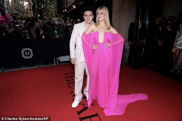 Sau đám cưới, vợ chồng con cả nhà Beckham xuất hiện bên nhau trên thảm đỏ “đại tiệc thời trang” lớn nhất hành tinh Met Gala 2022 được tổ chức tại Bảo tàng Nghệ thuật Metropolitan (New York, Mỹ) tối ngày 2/5, giờ địa phương. Cô dâu mới mặc chiếc đầm xẻ ngực táo bạo màu hồng cánh sen của Valentino, khoe thân hình thon nuột, lấp ló vòng một không nội y nâng đỡ.