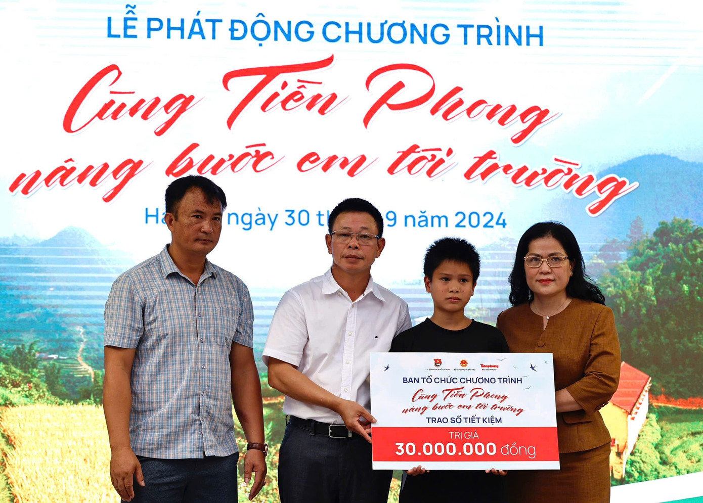 Thứ trưởng Bộ GD&amp;ĐT Nguyễn Thị Kim Chi (ngoài cùng bên phải) cùng Nhà báo Phùng Công Sưởng, Tổng biên tập Báo Tiền Phong trao sổ tiết kiệm cho em Hoàng Anh Quân.