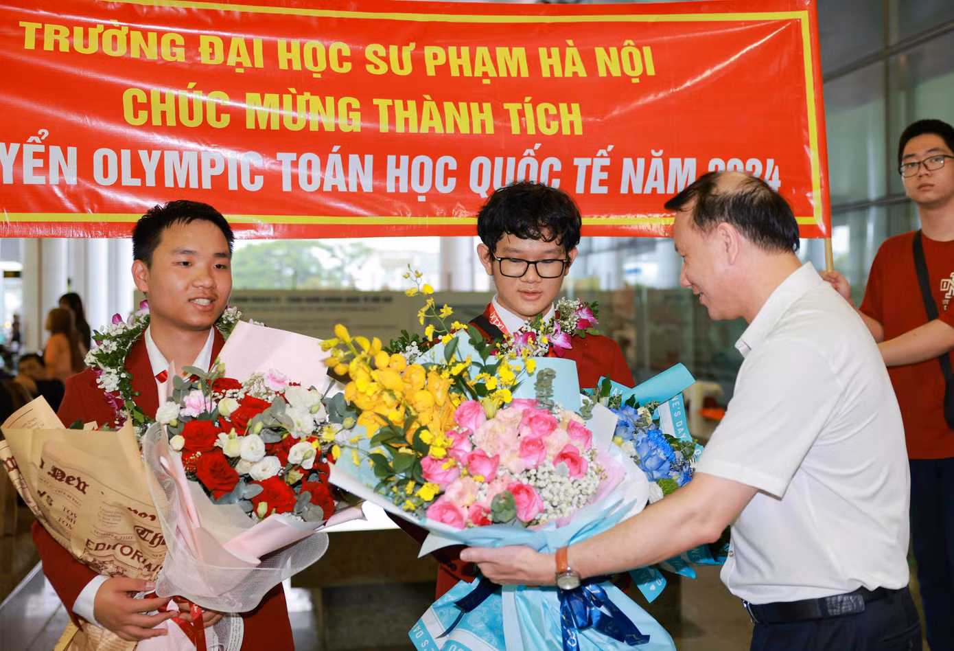 PGS.TS Nguyễn Đức Sơn, Hiệu trưởng Trường ĐH Sư phạm Hà Nội tặng hoa chúc mừng 2 học sinh của Trường THPT Chuyên Đại học Sư phạm Hà Nội trong đội tuyển Olympic Toán học năm 2024 của Việt Nam tham gia thi quốc tế tại Vương quốc Anh.
